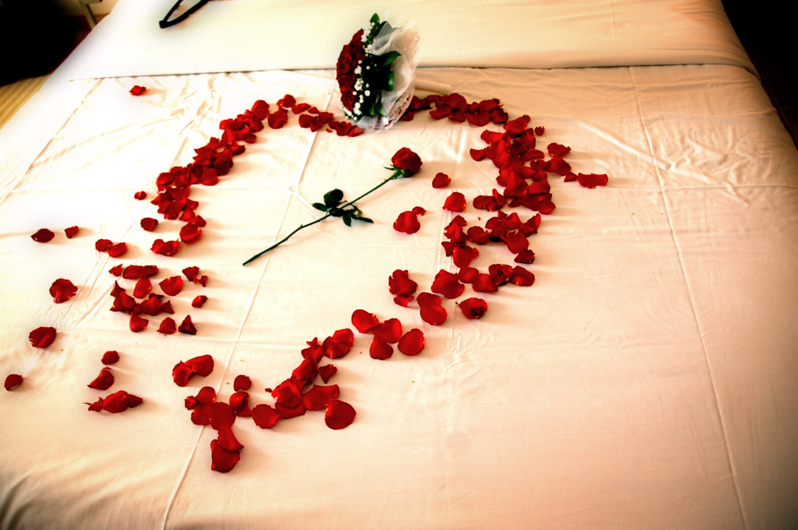 сердце из лепестков роз на кровати
